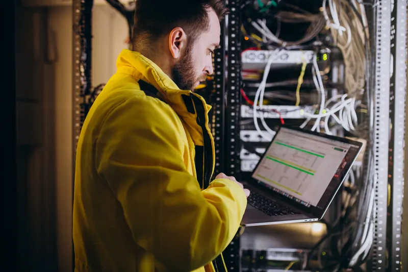 A network engineer working on switching equipment in a data centre